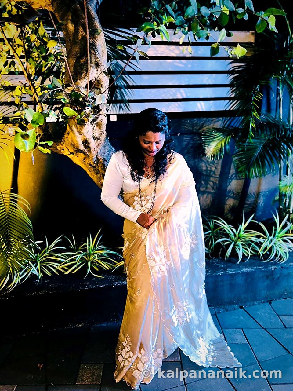 Kalpana in a white saree at night