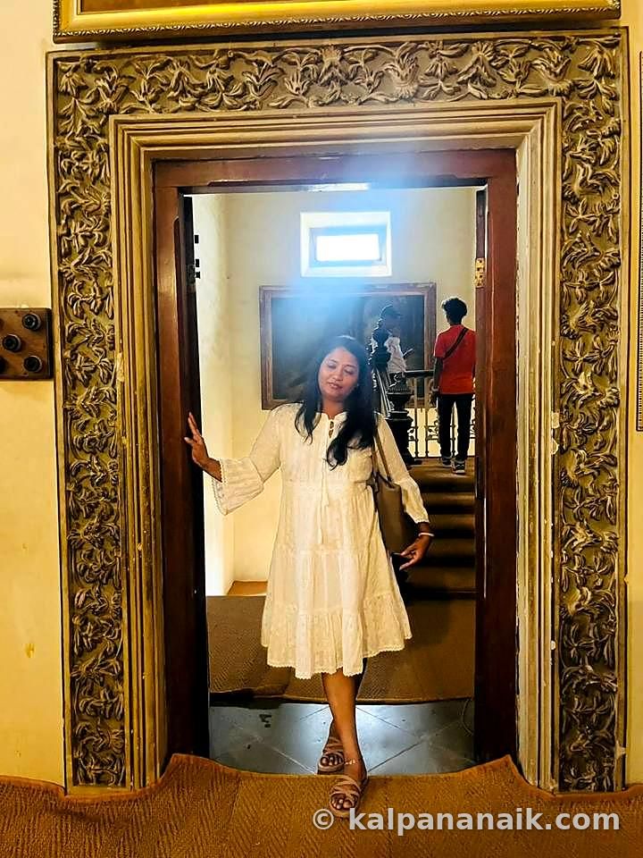 Kalpana in a white dress in a golden doorway