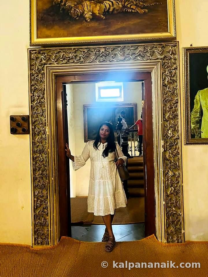 Kalpana in a white dress in a golden doorway