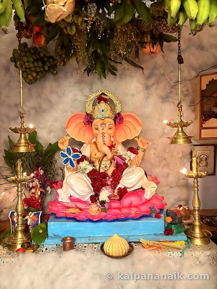 Ganesh idol between brass lamps