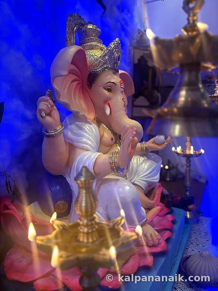 Ganesh idol by brass lamps